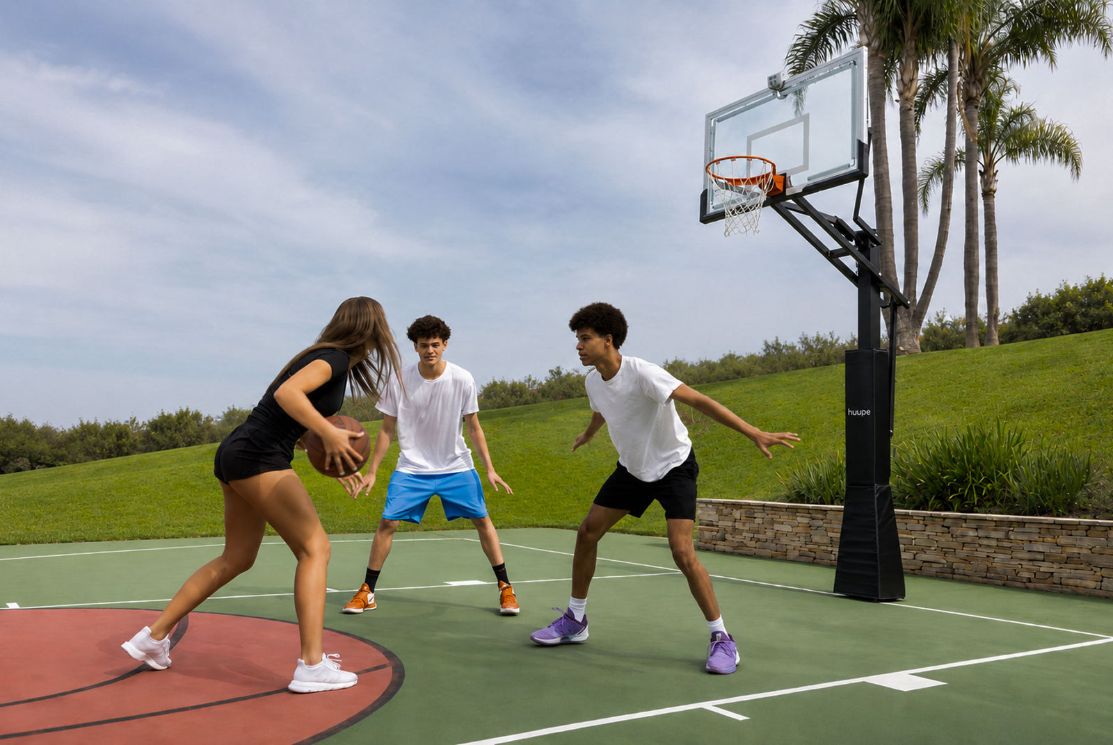 Kids playing pickup on a backyard court under the huupe ARENA